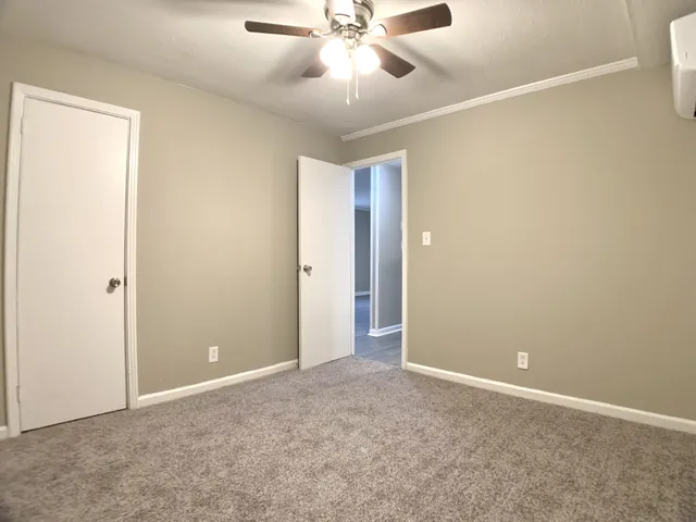 an empty room with closet and a chandelier fan