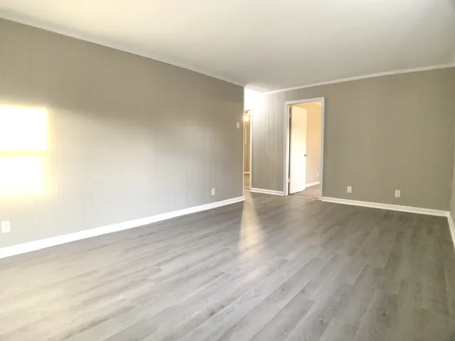a view of an empty room with wooden floor