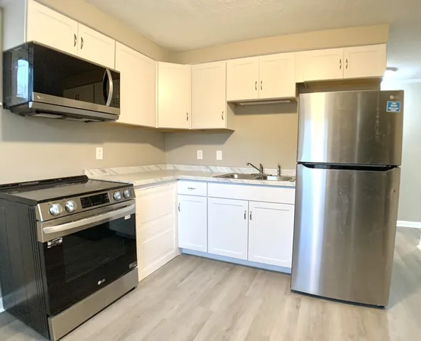 a kitchen with a refrigerator stove and white cabinets