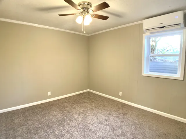 an empty room with a window and a fan