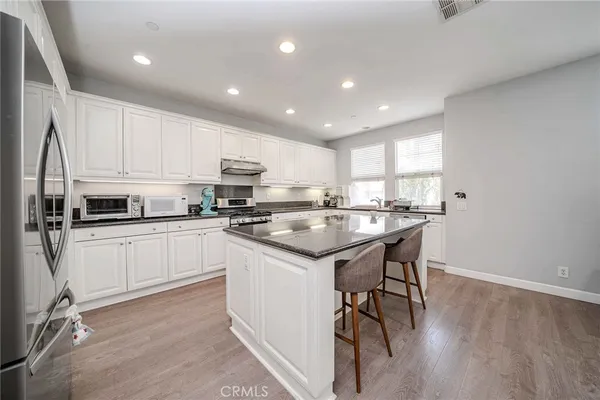 a kitchen with a sink stainless steel appliances and white cabinets