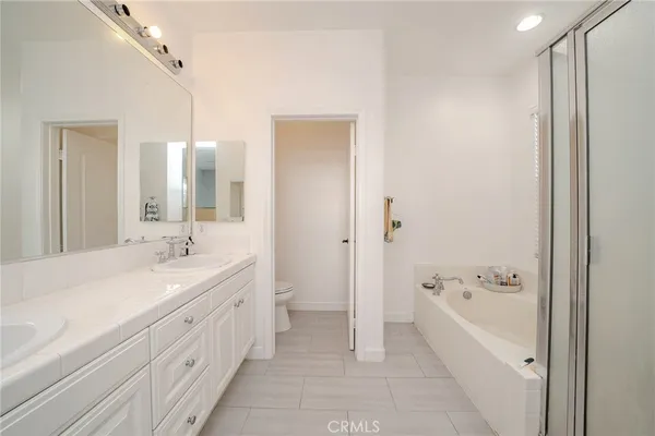 a spacious bathroom with a bathtub shower sink double and mirror
