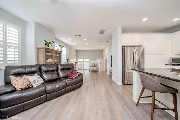 a living room with furniture and a refrigerator