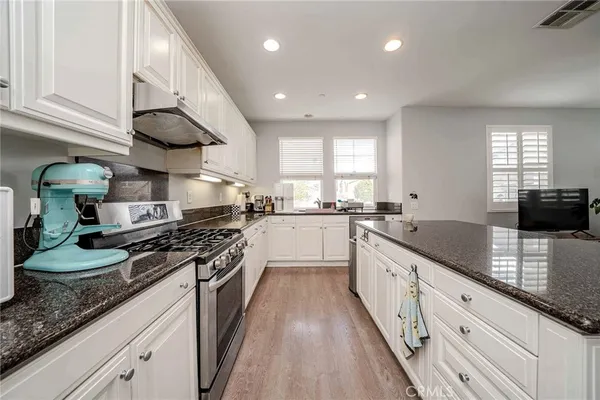 a large kitchen with stainless steel appliances granite countertop a stove a sink and a granite counter tops