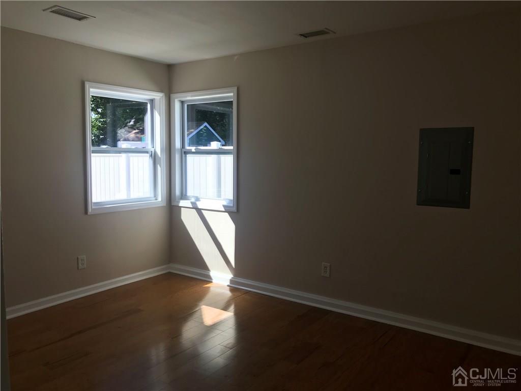 42 Kenmore Road Edison, NJ 08817 - Photo 2 of 14 an empty room with wooden floor and windows