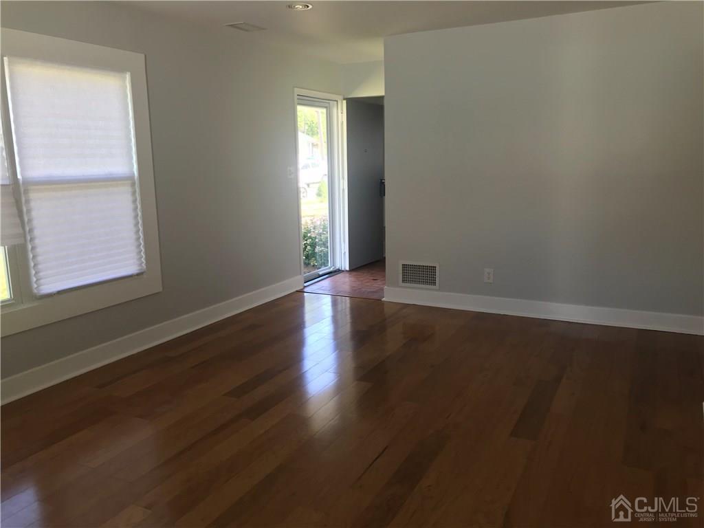 42 Kenmore Road Edison, NJ 08817 - Photo 4 of 14 an empty room with wooden floor and windows