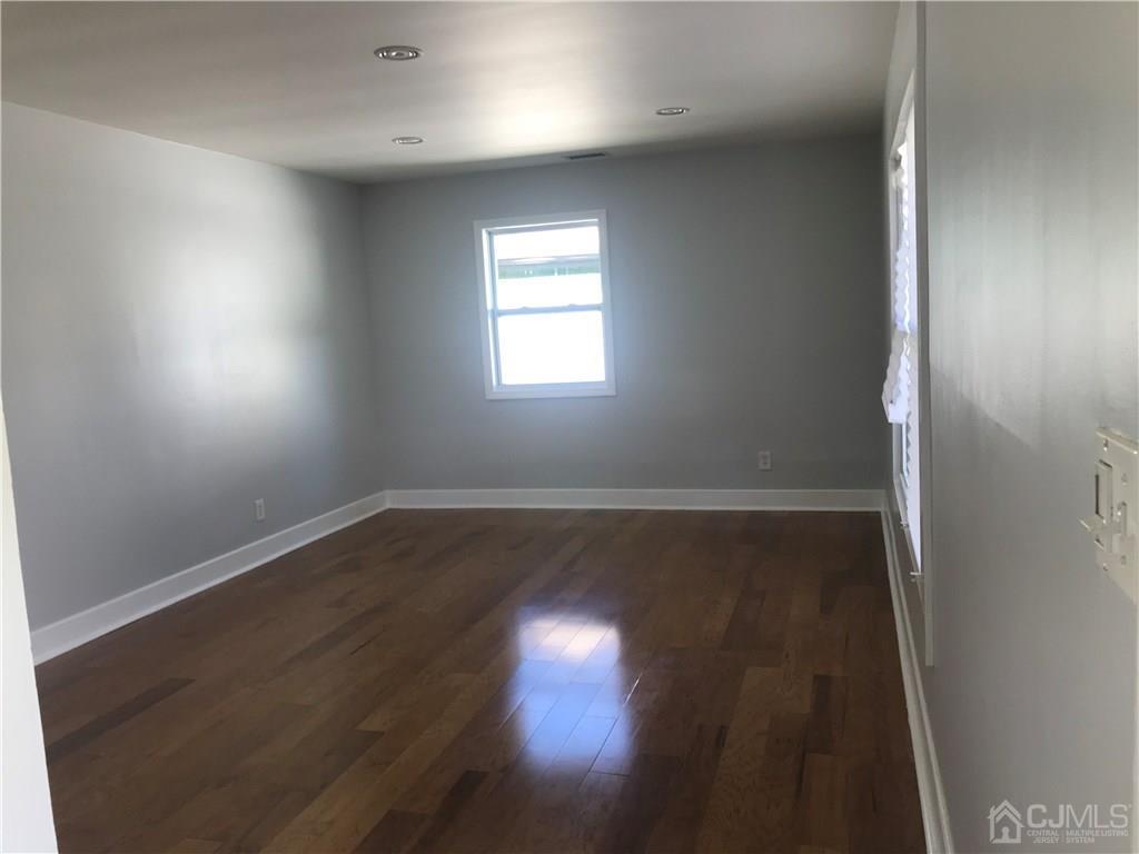 42 Kenmore Road Edison, NJ 08817 - Photo 5 of 14 an empty room with wooden floor and windows