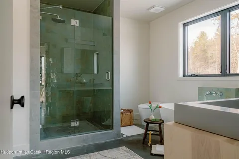 a bathroom with a shower a mirror and a sink