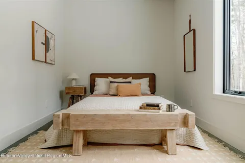 a bedroom with a bed and painting on the wall