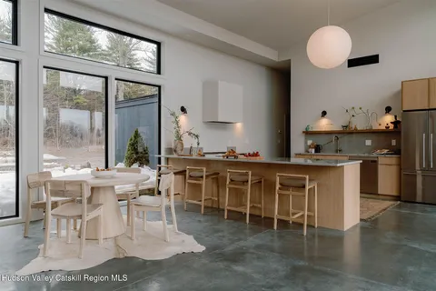 a kitchen with stainless steel appliances granite countertop a stove a sink a dining table and chairs
