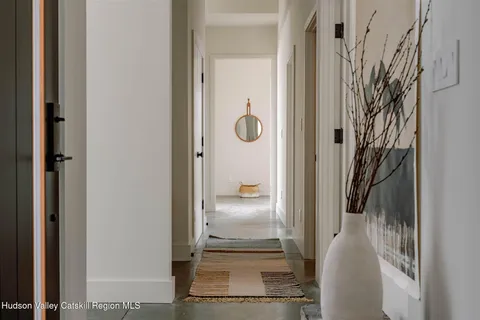 a view of a hallway with wooden floor and glass door