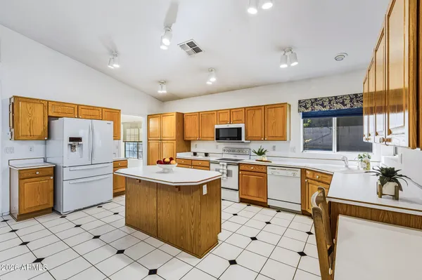 a large kitchen with kitchen island a counter top space a sink a stove and cabinets