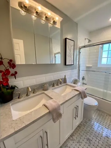 a bathroom with a sink vanity granite toilet tub and shower