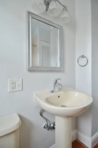 a bathroom with a sink a toilet and mirror