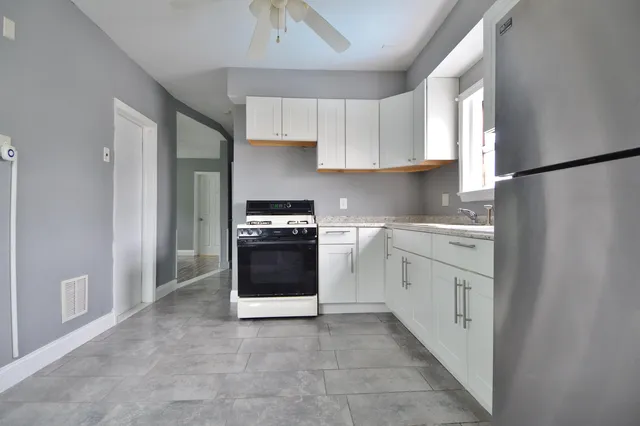 a kitchen with white cabinets and white appliances