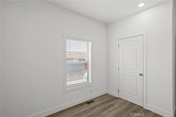 an empty room with wooden floor and window