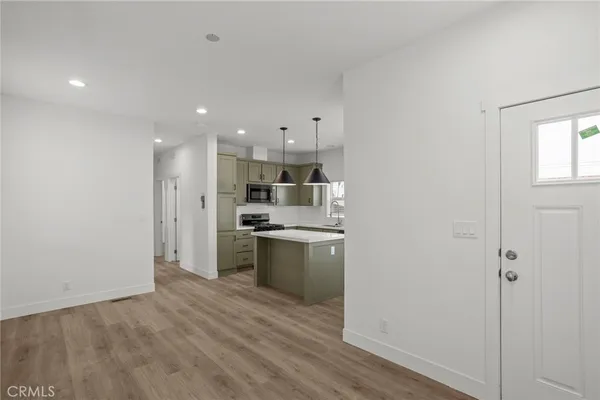 a kitchen with a refrigerator and a stove top oven