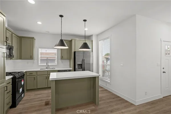 a kitchen with a sink a counter top space stainless steel appliances and cabinets