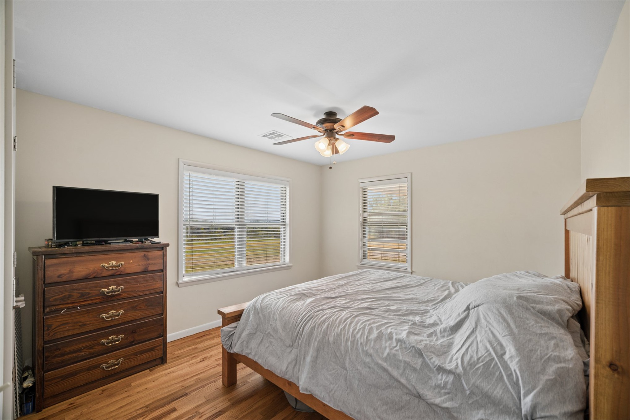 49301 South 360 Road Pawnee, OK 74058 - Photo 20 of 44 Wood-finish flooring, ceiling fan with integrated lighting, two windows with blinds, and neutral wall tones