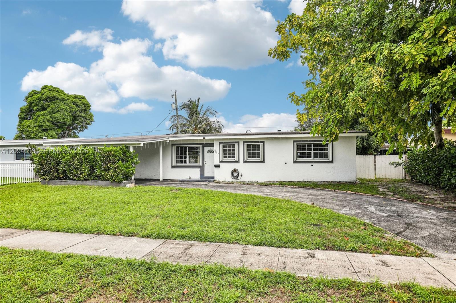 571 Northeast 172nd Street North Miami Beach, FL 33162 - Photo 1 of 33 Front of the home with circular driveway and lawn