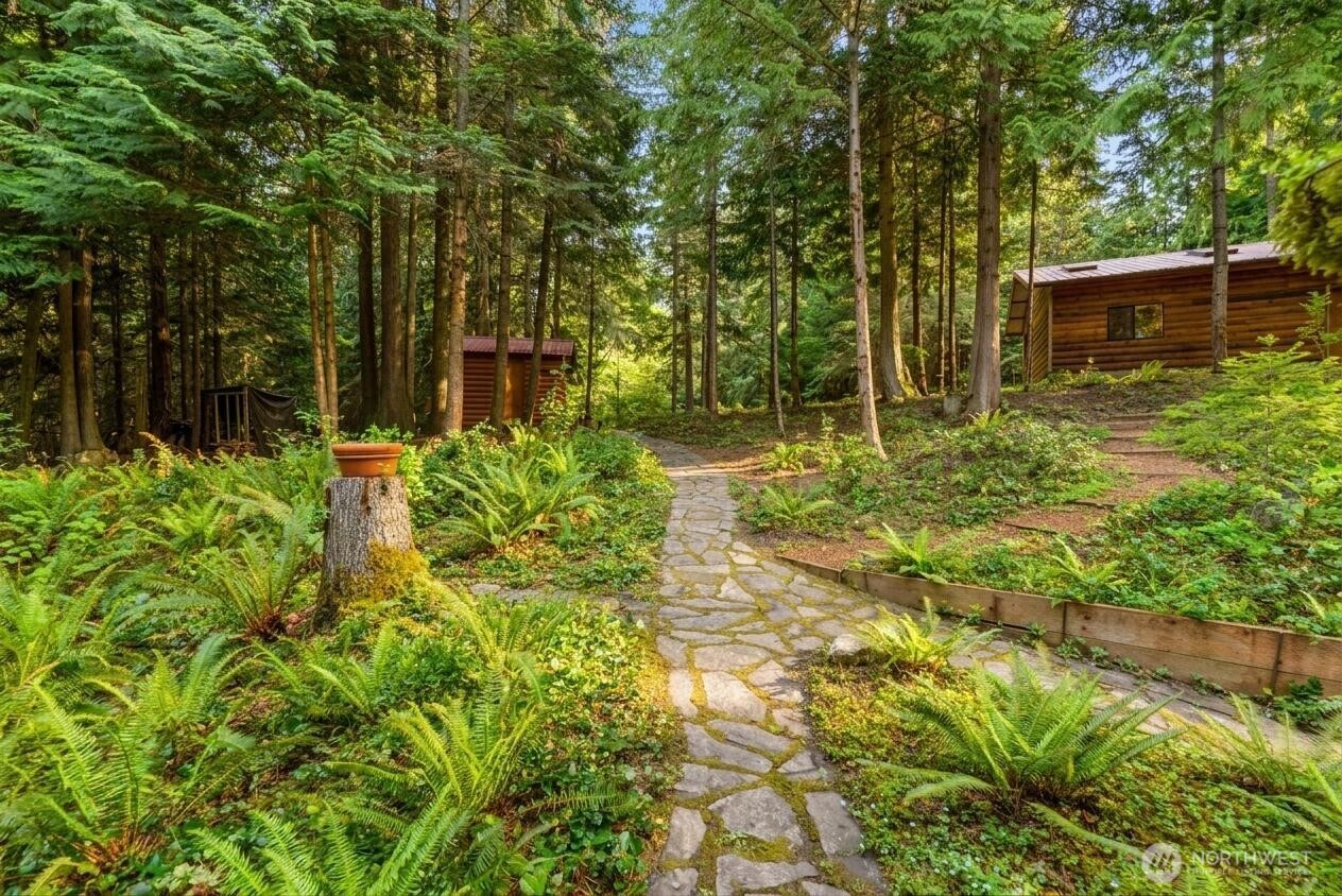 214 Cougar Crest Road Sequim, WA 98382 - Photo 27 of 30 a backyard of a house with lots of green space and fountain in the back