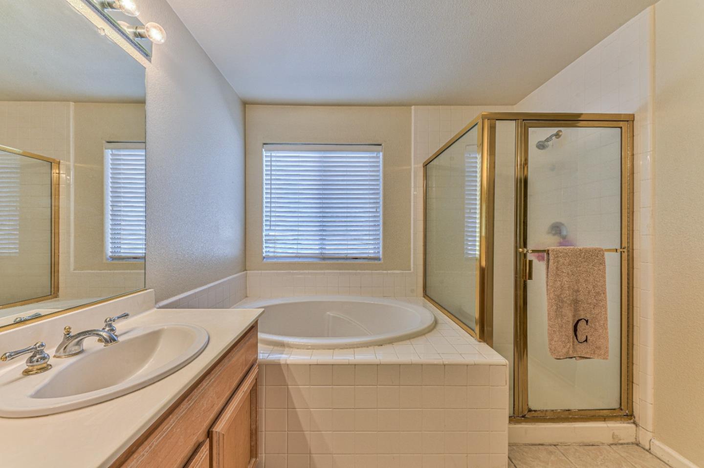 10 Whitman Circle Salinas, CA 93906 - Photo 26 of 33 a bathroom with a granite countertop sink a mirror and a bathtub