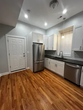 a kitchen with granite countertop a refrigerator and a sink