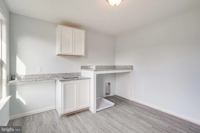 a view of a kitchen with a sink dishwasher and wooden floor