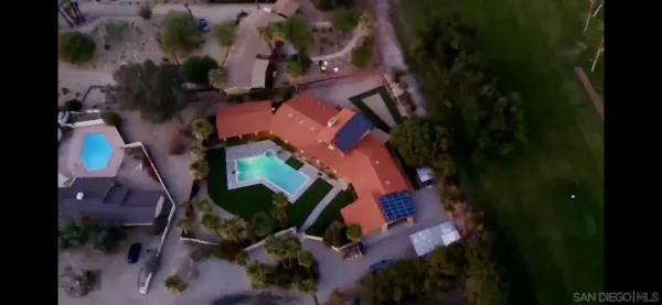 an aerial view of a house with a yard and garden