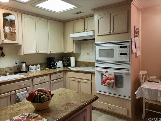 a kitchen with stainless steel appliances granite countertop a stove and cabinets