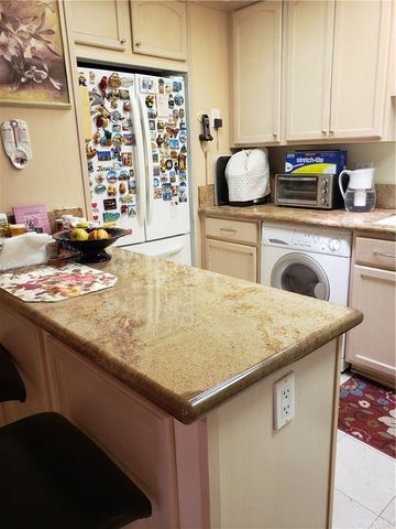 a kitchen with stainless steel appliances kitchen island granite countertop a sink a stove and white cabinets