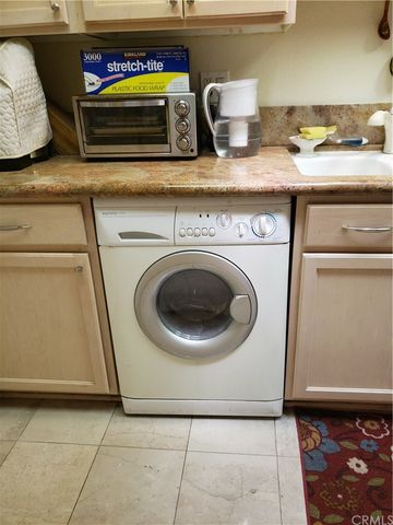 a kitchen with white cabinets and a stove with wooden floor