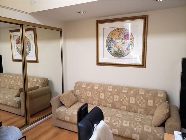 a living room with furniture and a shelf with books on a stool