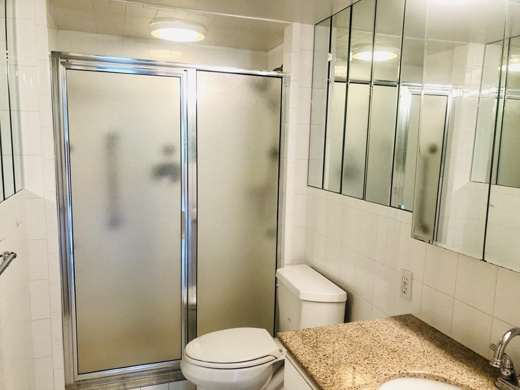 402 Paradise Road, Unit 2L Swampscott, MA 01907 - Photo 3 of 11 a bathroom with a granite countertop bathtub shower sink vanity and toilet
