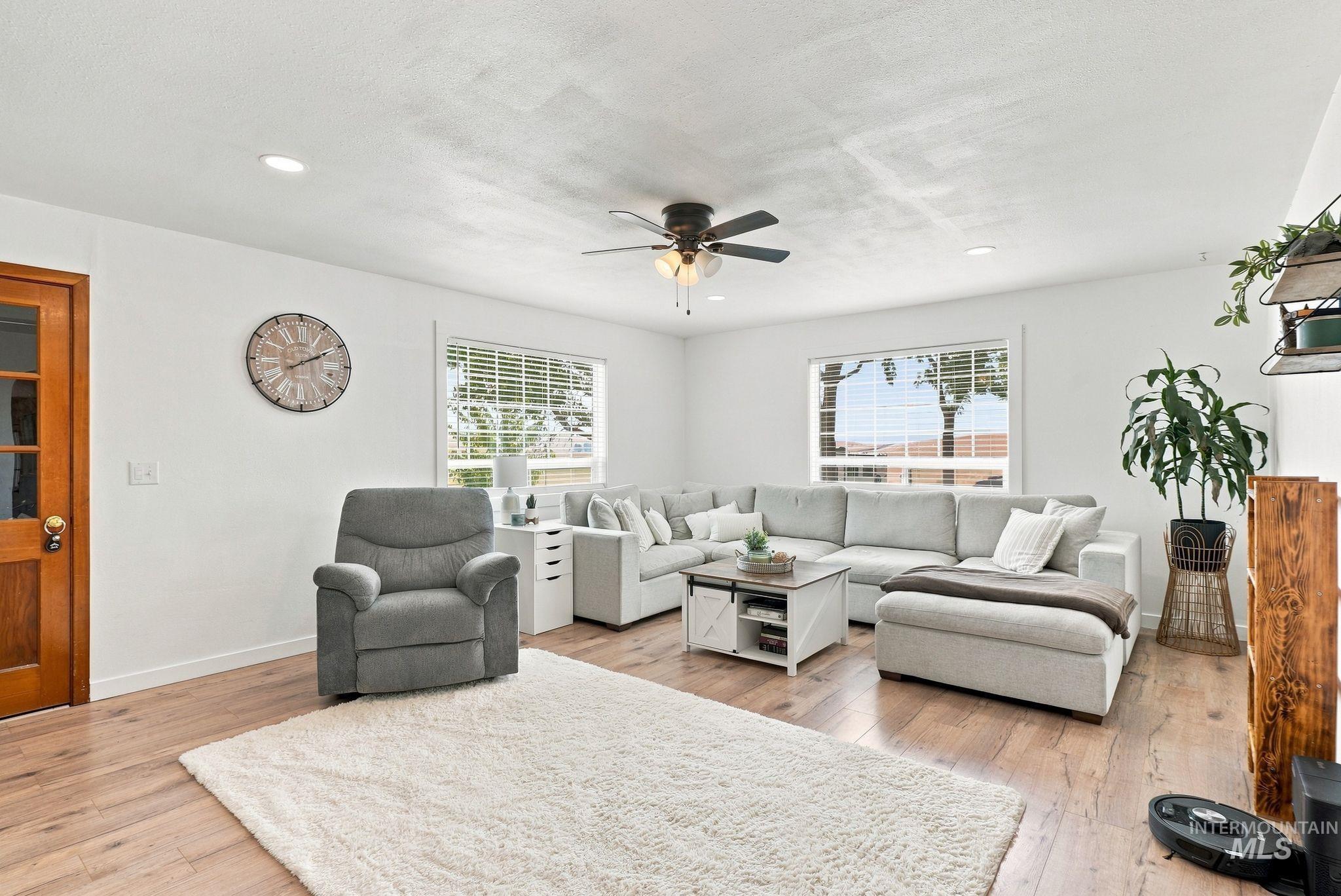 16078 Hoffman Road Kendrick, ID 83537 - Photo 7 of 47 Wood-finish flooring, white walls, ceiling fan with integrated lighting, recessed lighting, and windows with blinds