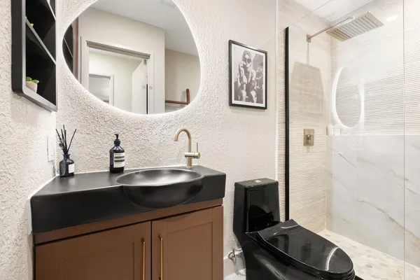 a bathroom with a sink a toilet and a mirror