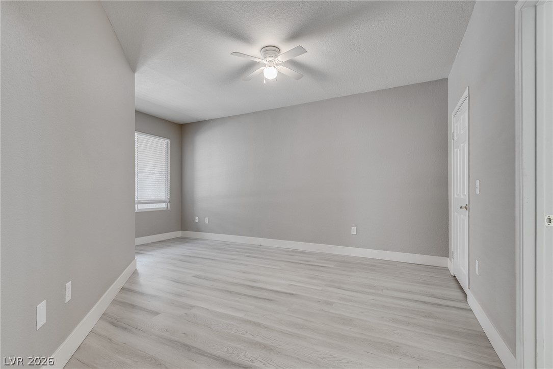 10550 West Alexander Road, Unit 1139 Las Vegas, NV 89129 - Photo 20 of 27 A well-lit bedroom with fresh flooring and a ceiling fan awaits your personal touch.
