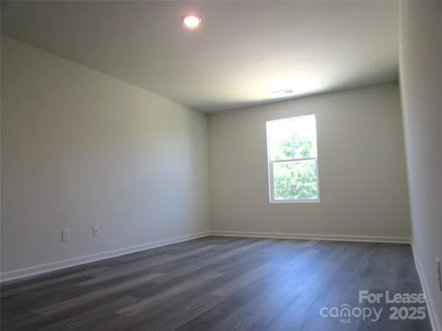 an empty room with wooden floor and window