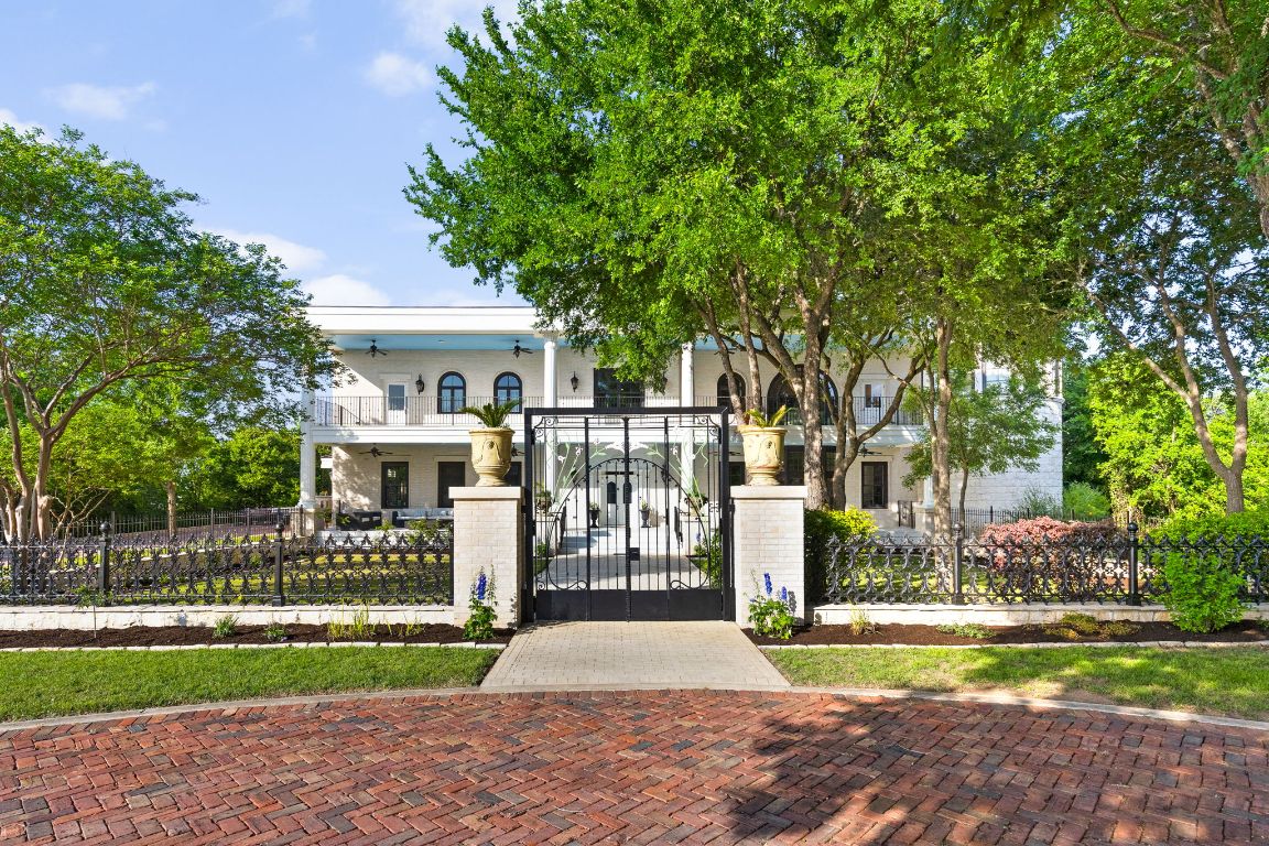 a front view of a house with a garden and trees