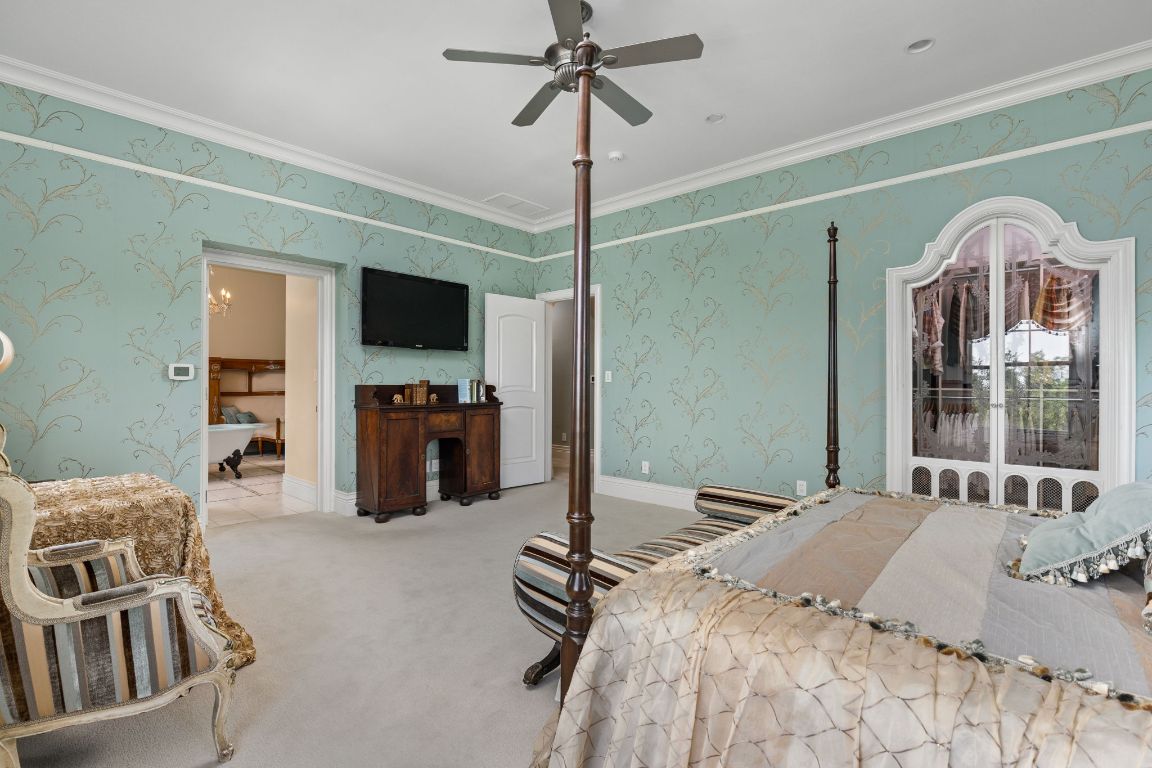 999 Schwarzlose Road New Braunfels, TX 78130 - Photo 16 of 39 a bedroom with a bed and a flat tv screen on a dresser