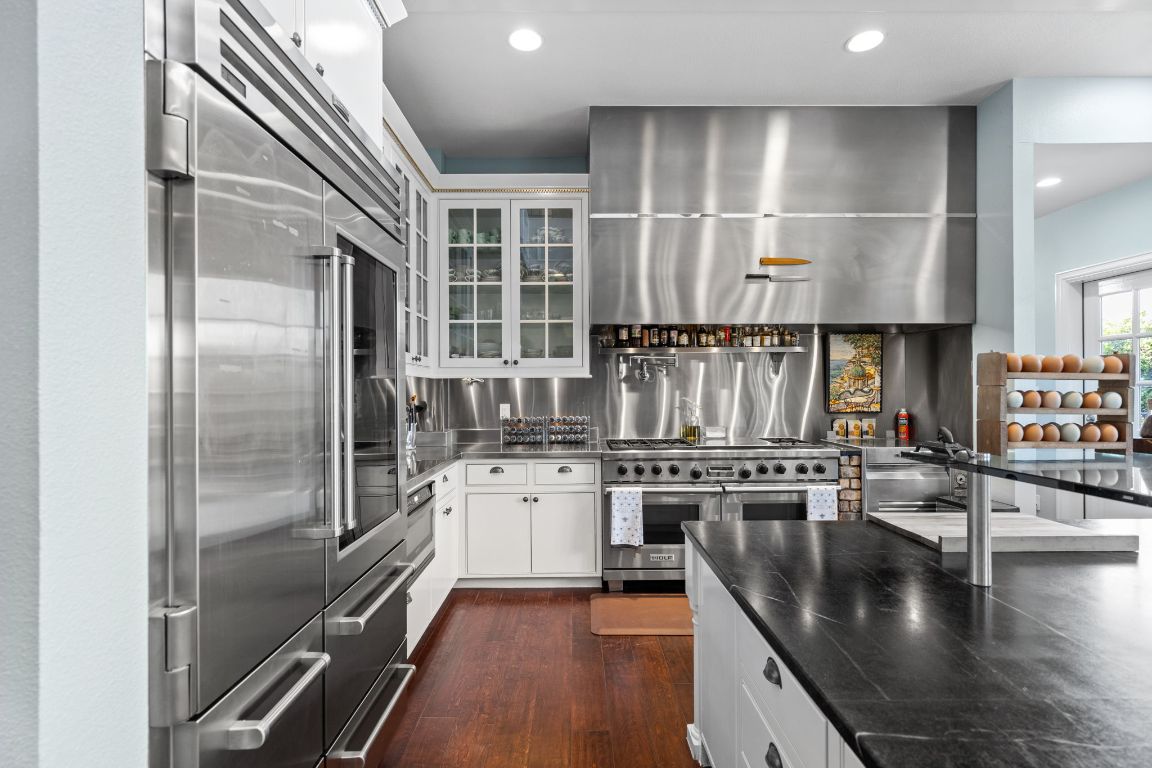 999 Schwarzlose Road New Braunfels, TX 78130 - Photo 7 of 39 a kitchen with stainless steel appliances granite countertop a refrigerator a stove and a refrigerator