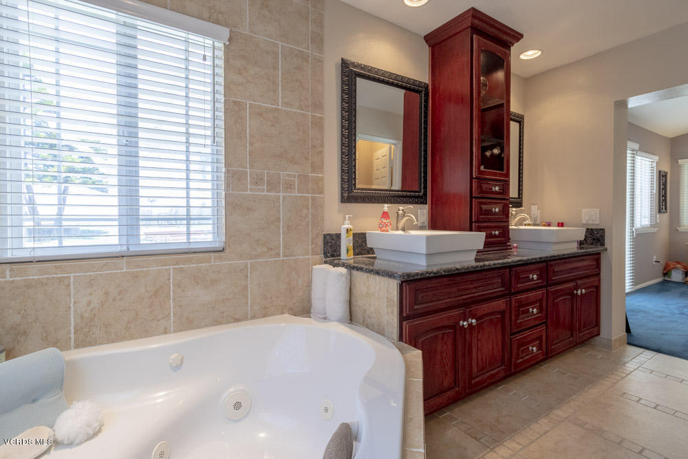 1795 Rambling Road Simi Valley, CA 93065 - Photo 31 of 60 a bathroom with a granite countertop bathtub sink and mirror