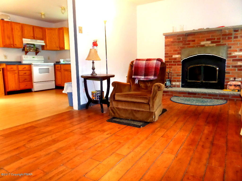 113 Lehman Road Bushkill, PA 18324 - Photo 9 of 23 a living room with furniture a fireplace and next to a window