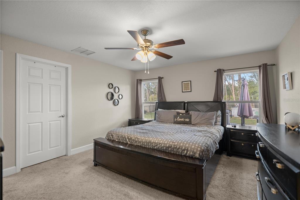 9609 Southwest 40th Terrace Ocala, FL 34476 - Photo 15 of 28 a bedroom with a bed and a chandelier