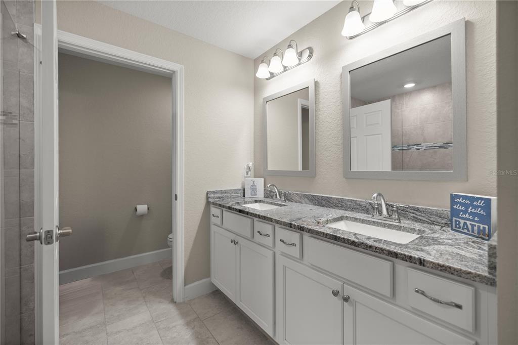 9609 Southwest 40th Terrace Ocala, FL 34476 - Photo 17 of 28 a bathroom with a granite countertop sink double and mirror