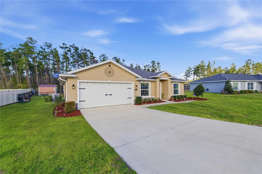 9609 Southwest 40th Terrace Ocala, FL 34476 - Photo 3 of 28 a front view of a house with a yard and garage