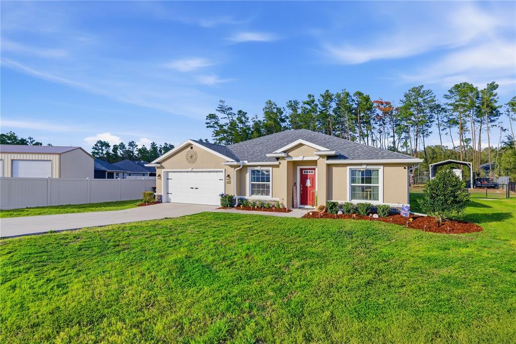 9609 Southwest 40th Terrace Ocala, FL 34476 - Photo 4 of 28 a front view of a house with a yard and garage