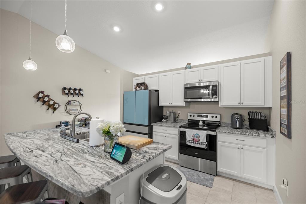 9609 Southwest 40th Terrace Ocala, FL 34476 - Photo 9 of 28 a kitchen with sink a microwave a stove and refrigerator