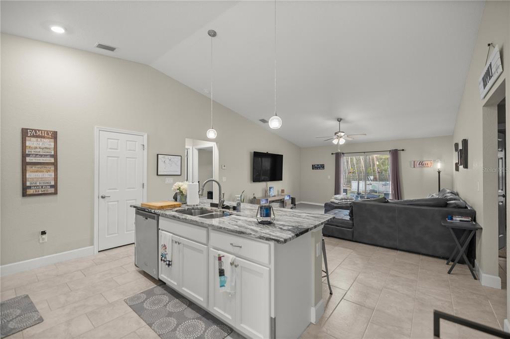 9609 Southwest 40th Terrace Ocala, FL 34476 - Photo 10 of 28 a large white kitchen with a stove a sink a dining table and chair