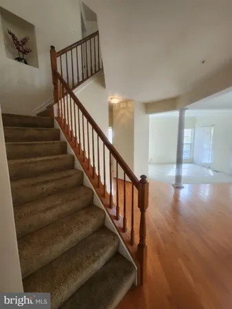 a view of staircase with lots of frames on wall and wooden floor